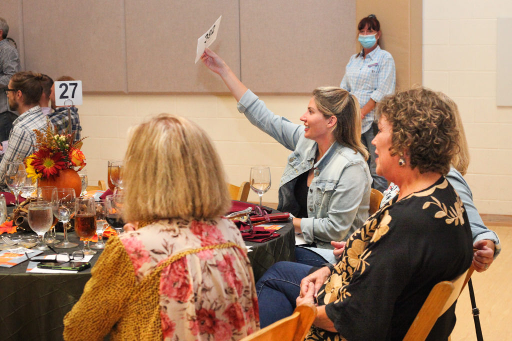 An enthusiastic bidder joins in the auction fun.